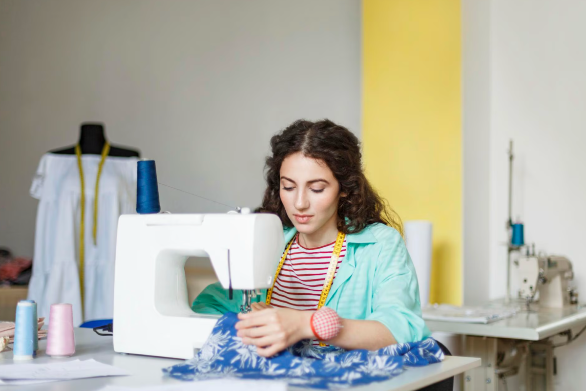 Mulher praticando depois de curso de costura gratuito